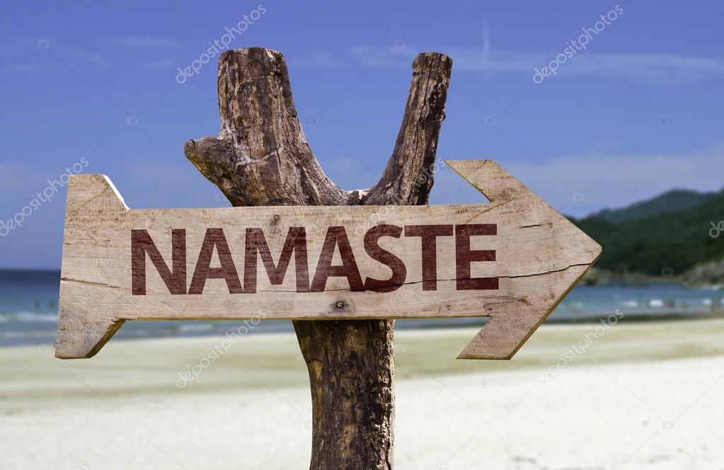 Namaste wooden sign with a beach on background