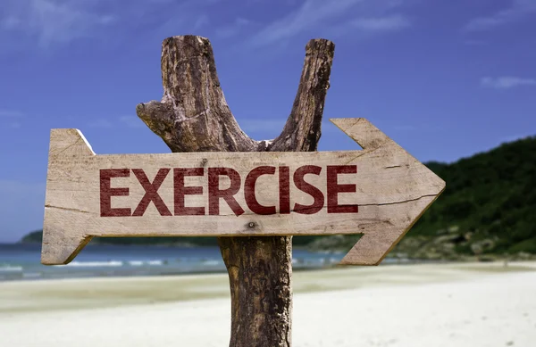 Exercise wooden sign with a beach on background — Stock Photo, Image