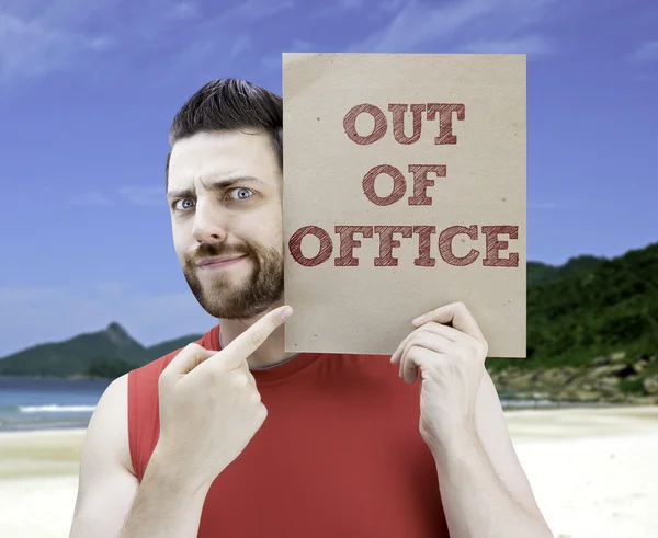 Man holding a card with the text Out Of Office — Stock Photo, Image