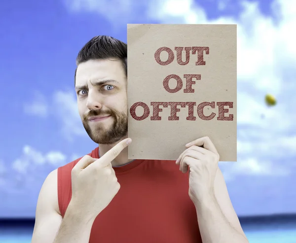 Man holding a card with the text Out Of Office — Stock Photo, Image