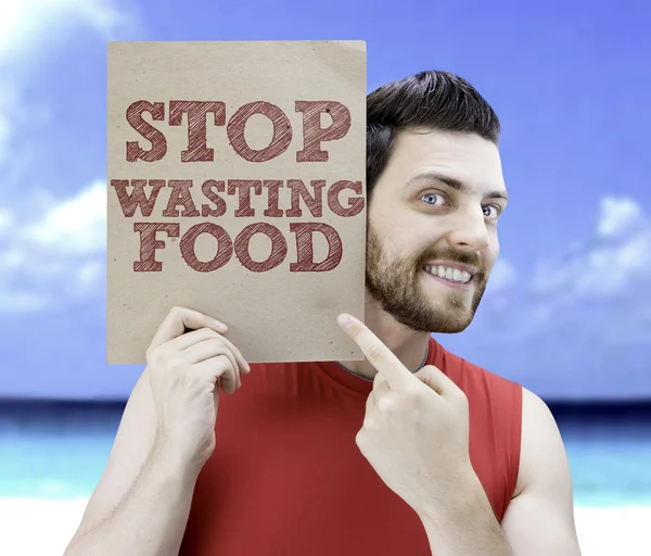 Homme tenant une carte avec le texte Stop Wasting Food — Photo