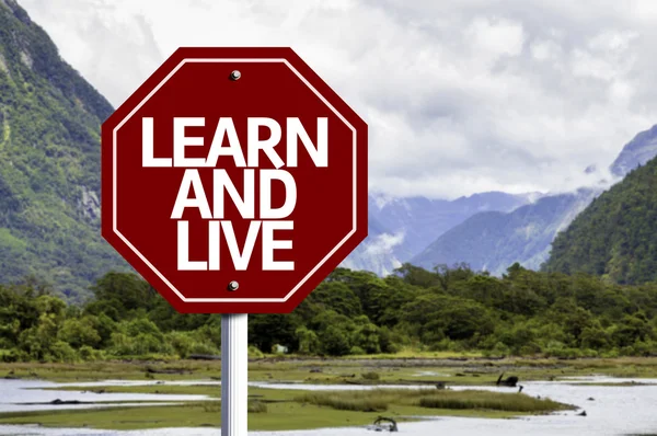 Aprender y vivir escrito en rojo señal de tráfico — Foto de Stock