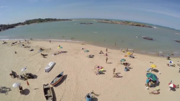 Turistas visitam a praia local — Vídeo de Stock