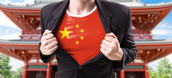 Businessman stretching suit with Chinese flag — Stock Photo, Image