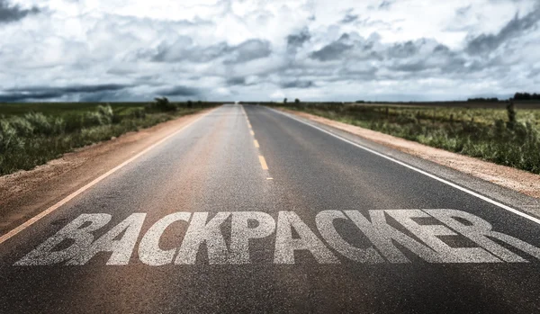 Backpacker on rural road — Stock Photo, Image