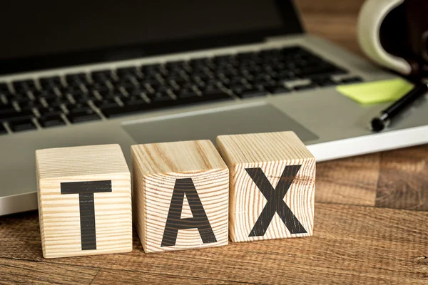 Tax written on a wooden cubes — Stock Photo, Image