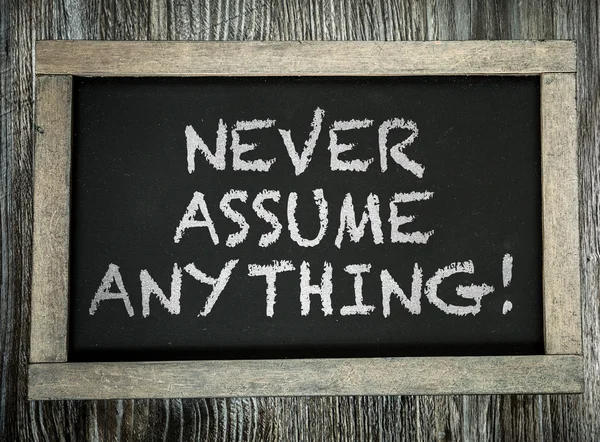 Never Assume Anything on chalkboard — Stock Photo, Image