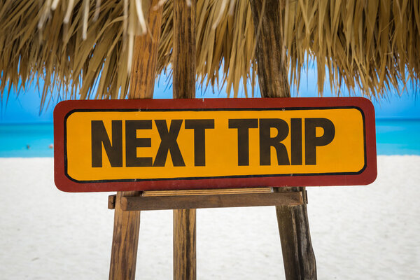 Next Trip sign with beach background