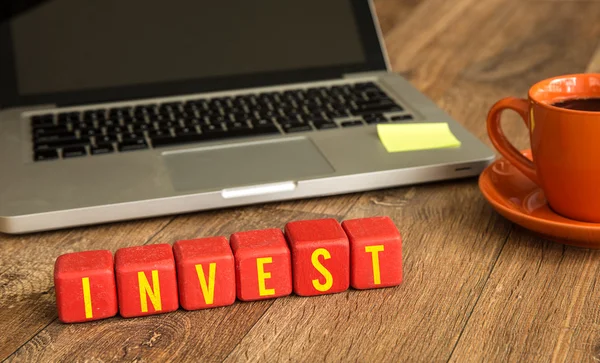 Invest written on a wooden cubes — Stock Photo, Image