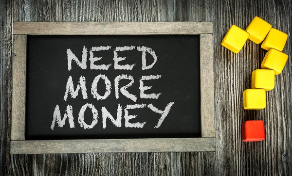 Precisa de mais dinheiro? em chalkboard — Fotografia de Stock