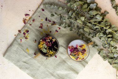 Tahta arka planda bir fincan kahve ve çiçekler.