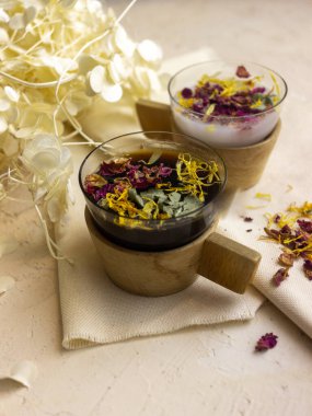 Tahta arka planda bir fincan kahve ve çiçekler.