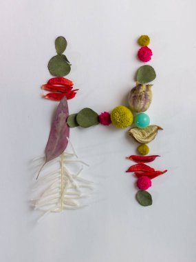 Beyaz arkaplanda çiçek ve yapraklardan oluşan harfler