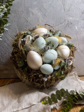 Yeşil yumurtalı Paskalya Yuvası ve ahşap arka planda söğüt ağaçları