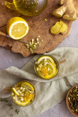 Ahşap zemin üzerinde limonlu ve zencefilli yeşil çay