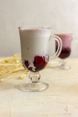 Smoothie berry smoothie pembe bir arka plan masanın üzerinde duruyor.