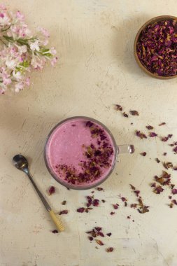 Smoothie berry smoothie pembe bir arka plan masanın üzerinde duruyor.