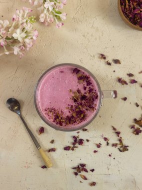 Smoothie berry smoothie pembe bir arka plan masanın üzerinde duruyor.