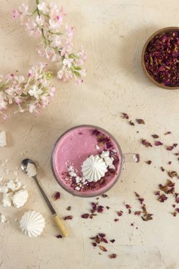 Smoothie berry smoothie pembe bir arka plan masanın üzerinde duruyor.
