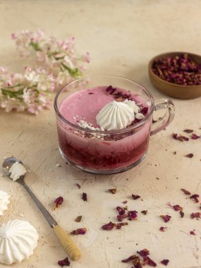 Smoothie berry smoothie pembe bir arka plan masanın üzerinde duruyor.