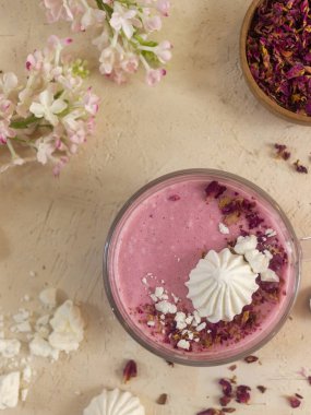 Smoothie berry smoothie pembe bir arka plan masanın üzerinde duruyor.