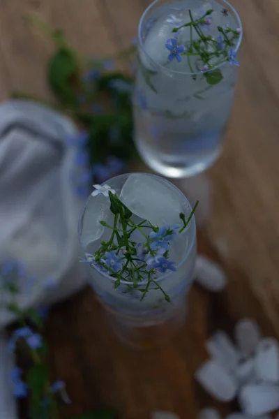 Vaso Hielo Con Agua Flores Azules Sobre Fondo Madera —  Fotos de Stock