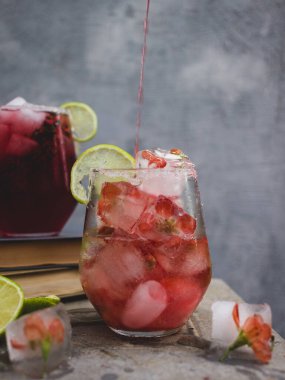 Buzlu bir bardak ve pembe bir içecek.