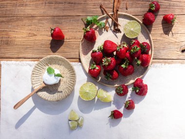 Ahşap bir arka planda seramik bir tabakta çilekler