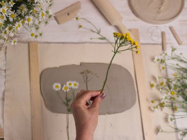 Hafif bir arkaplanda kil çömlek araçları ile çalışan çömlek 