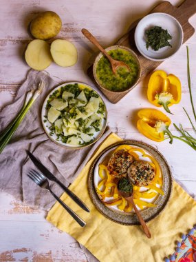 Hafif ahşap masada Fransız usulü patates salatası ve tavuk pirzolası.