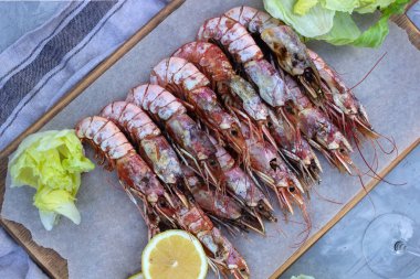 Balık aperatifleri ahşap bir masada beyaz şarap manzaralı Langoustines