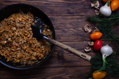 Ahşap bir masada mantarlı kızarmış Rus patatesleri.