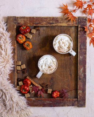 Sonbahar, bir fincan kahveyle ve ahşap arka planda sonbahar yapraklarıyla sakin bir hayattır.