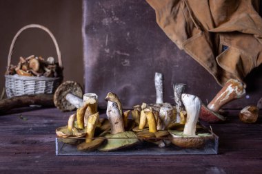 Masanın üzerinde farklı türde yabani mantarlar uzanıyor.