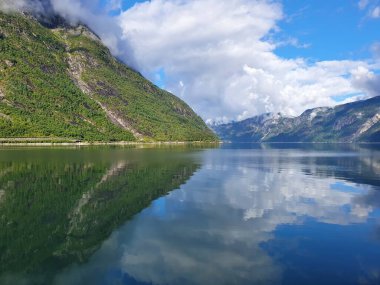 Gökyüzünün ve dağların yansıması fiyordun mavi suyunda - Eidfjord