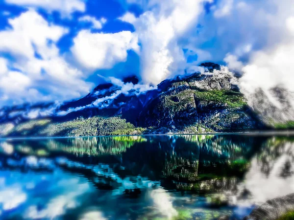 Gökyüzünün ve dağların yansıması fiyordun mavi suyunda - Eidfjord