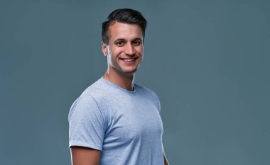 mavi arka planı gülümseyen yakışıklı bir genç adam portresi.
