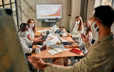 Diverse business worker discuss and meeting while Wearing Medical Mask as protection from corona virus. New normal office working. Group of multiethnic people in business reopen. flu prevent healthy