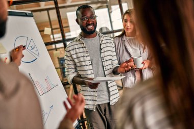 Bir grup genç iş adamı modern bir ofiste bir karatahta üzerinde iş planı tartışıyorlar. Birlikte çalışan başarılı bir hipster takımı. Bağımsızlar.