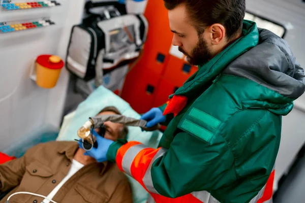 Ένας Άνδρας Νοσοκόμος Στολή Βάζει Αναπνευστήρα Οξυγόνο Για Βοηθήσει Έναν — Φωτογραφία Αρχείου