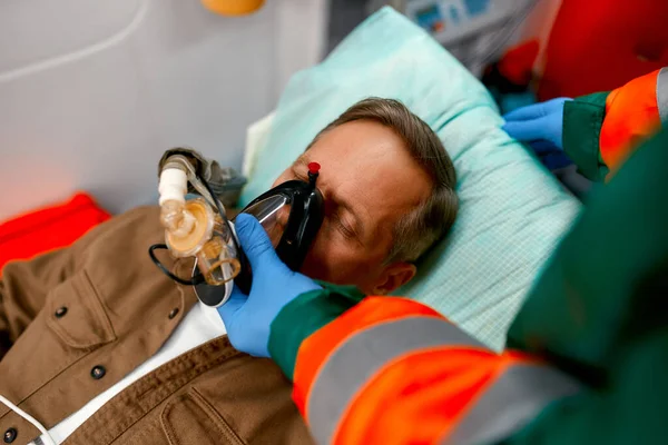 Ένας Άνδρας Νοσοκόμος Στολή Βάζει Αναπνευστήρα Οξυγόνο Για Βοηθήσει Έναν — Φωτογραφία Αρχείου