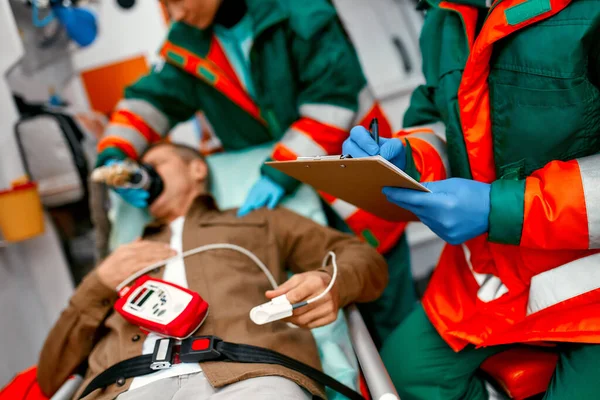 Μια Τραυματιοφορέας Στολή Βάζει Αναπνευστήρα Οξυγόνο Για Βοηθήσει Έναν Ηλικιωμένο — Φωτογραφία Αρχείου