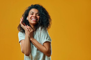 İyimser genç başını eğiyor ve yeni kulaklıklarla müzik dinliyor, kaygısız bir hayatı var, izin günlerinde boş vakit geçiriyor, günlük kıyafetler giyiyor, sarı duvarda izole edilmiş..