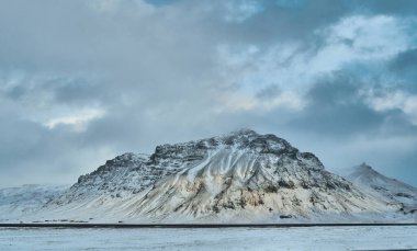 Güzel karla kaplı manzara, akşam gökyüzü bulutlarla kaplı, dağların manzarası ve terk edilmiş rüzgarlı çöl..