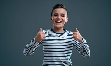 Gri arka planda izole edilmiş mutlu çocuk portresi..