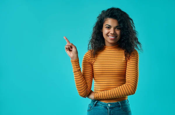 Afro-Amerikalı bir kadının yatay portresi boş bir alanda başparmağıyla olduğunu gösteriyor. Reklam ve insanlar.