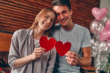 Evdeki güzel genç çift. Sevgililer Günü 'nü kutlarken birbirlerine sarılıp, öpüşüp, birlikte vakit geçirmekten zevk alan sevgi dolu bir çift..