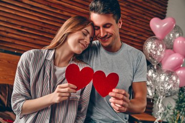 Evdeki güzel genç çift. Sevgililer Günü 'nü kutlarken birbirlerine sarılıp, öpüşüp, birlikte vakit geçirmekten zevk alan sevgi dolu bir çift..