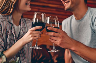 Yatak odasında şarap kadehleriyle genç bir çiftin görüntüsü. Sevgililer Günü. Yıldönümü. Doğum günü.