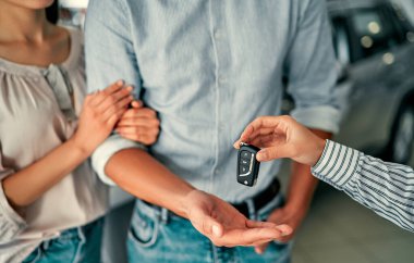 Yakın plan bir çift resmi galeride bir araba aldı ve müdürden anahtarları aldı..